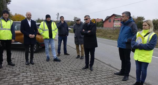 Uczestnicy odbioru – osiem osób, w tym Burmistrz Drzewicy Janusz Reszelewski i Zastępca Burmistrza Dominik Niemirski – stoją przy przebudowanej drodze powiatowej w Krzczonowie