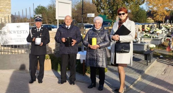 zworo społeczników TPD – dwie panie i dwóch panów – stoi z puszkami kwestarskimi obok wejścia na głównej alei cmentarza parafialnego w Drzewicy