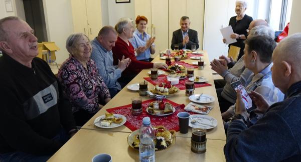  Przy stole siedzi kilkanaście osób - niewidomi i niedowidzący z opiekunami, Dyrektor RCK Alina Szymańska oraz Burmistrz Drzewicy Janusz Reszelewski. Stoi Pani Aleksandra Domańska