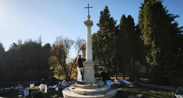 Prace montażowe przy odrestaurowanej kamiennej przydrożnej Kolumnie Toskańskiej z wieńczącym ją krzyżem. 